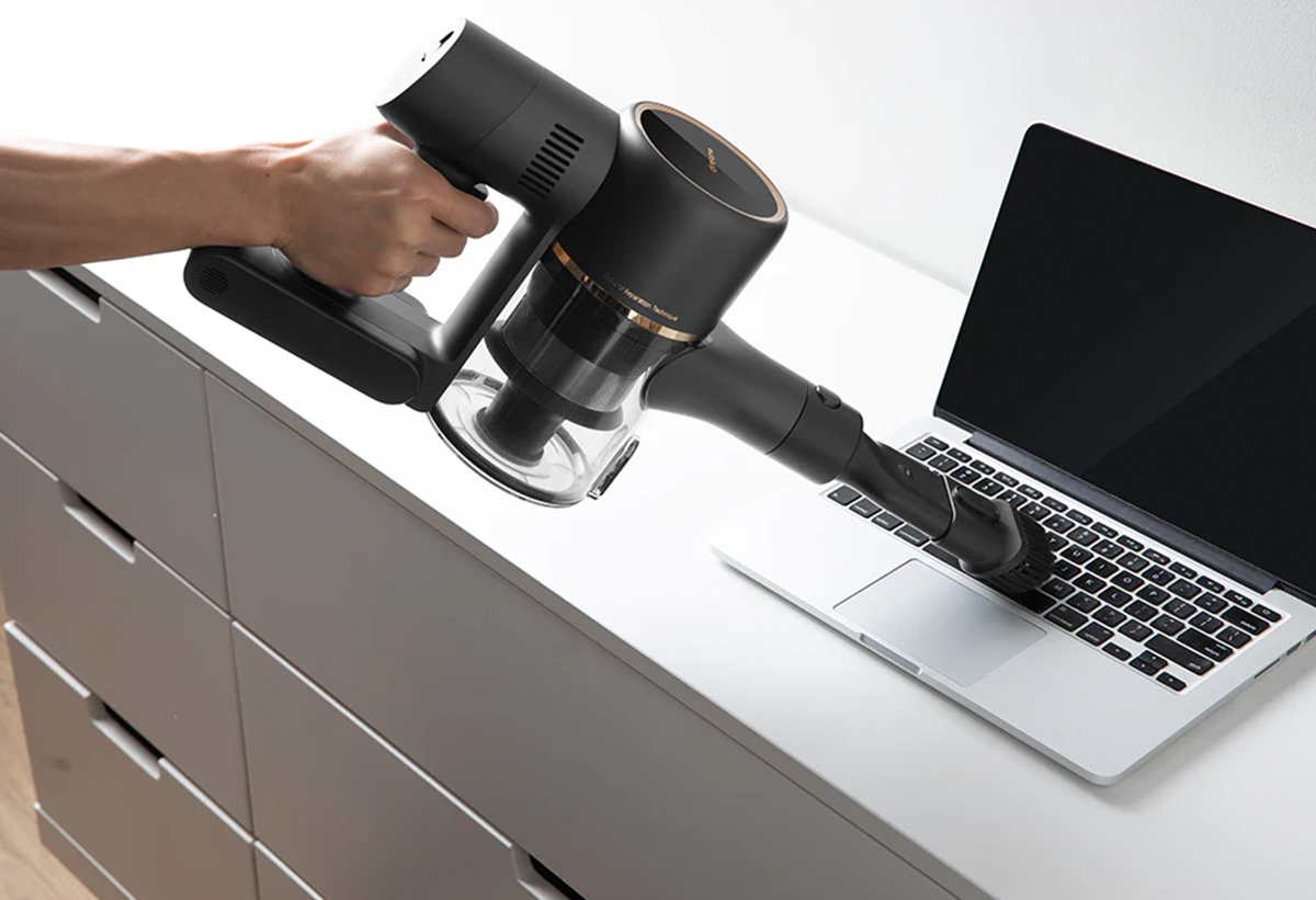 Απεικονίζεται η χρήση της σκούπας για τον καθαρισμό ενός λάπτοπ.